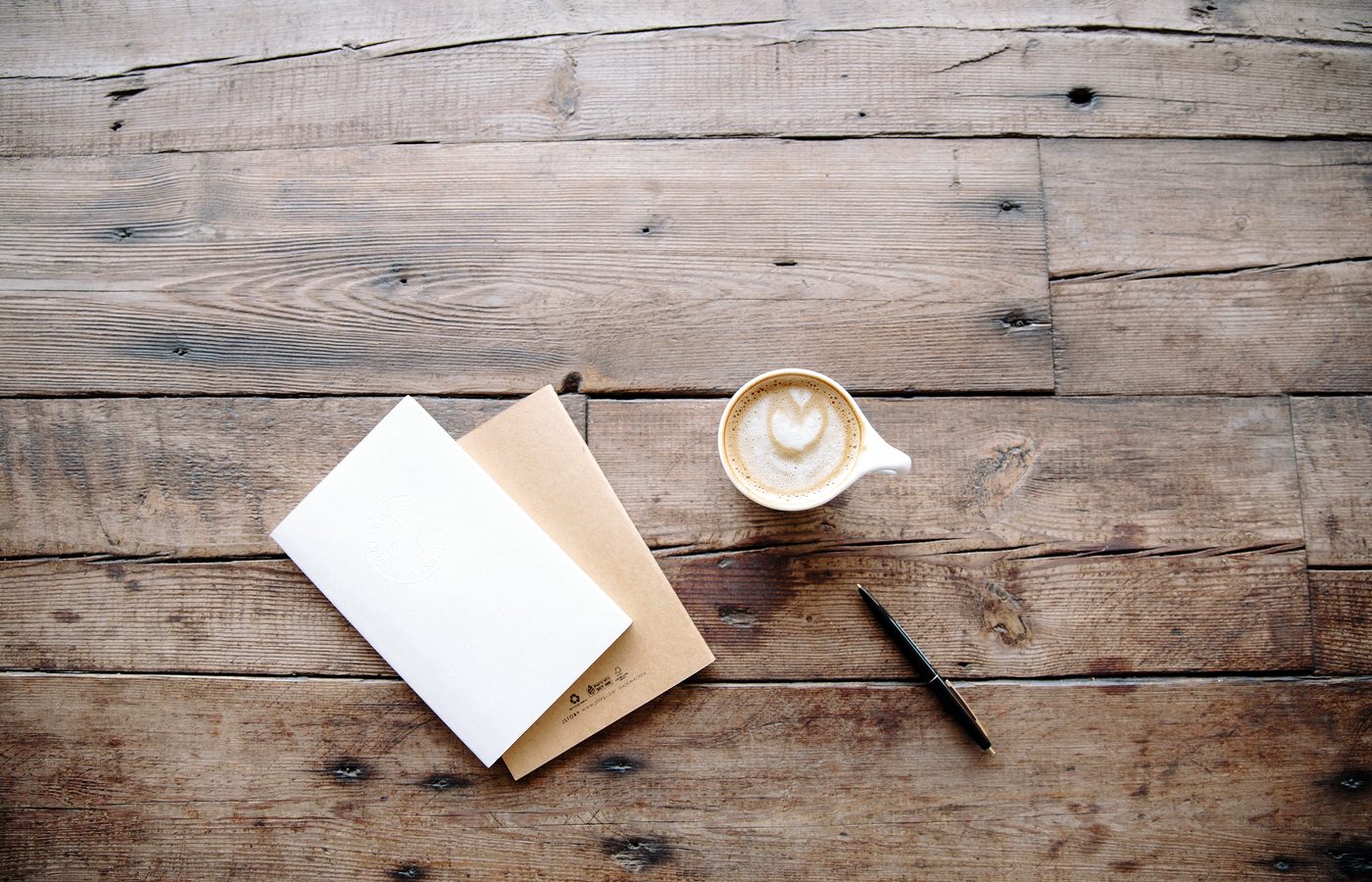 Carnet, stylo et tasse de café sur un plan de travail